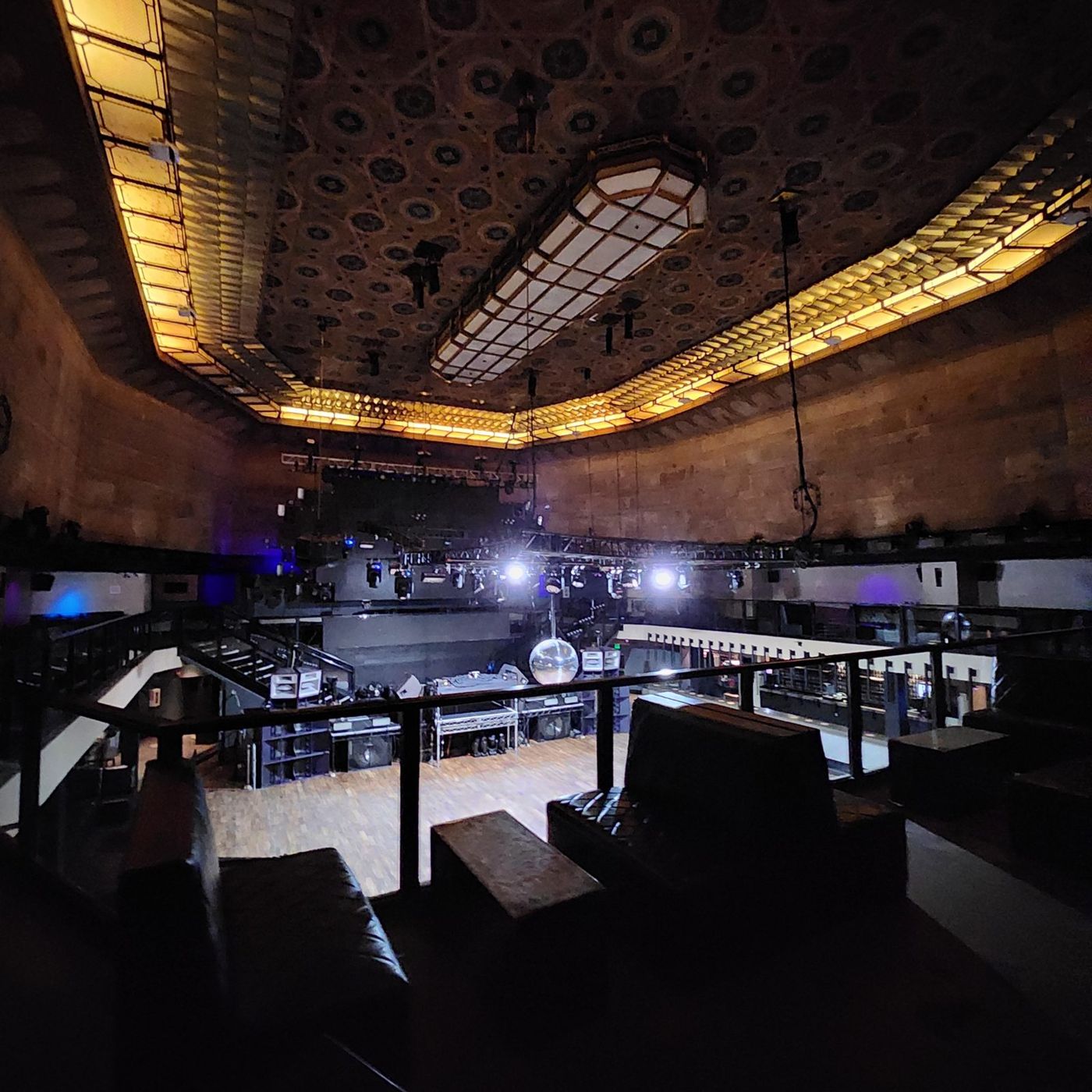 The venue mezzanine and stage beneath the illuminated ceiling cove